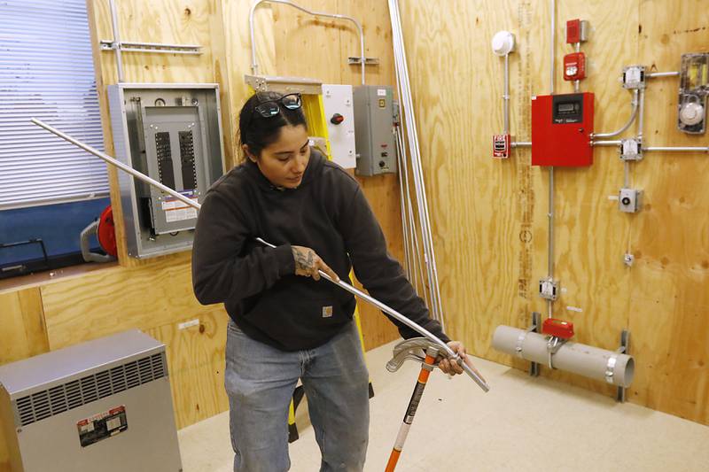 Kassandra Lopez bends conduit on Monday, Dec. 9, 2024, in a training room at International Brotherhood of Electrical Workers Local 117 in Crystal Lake.