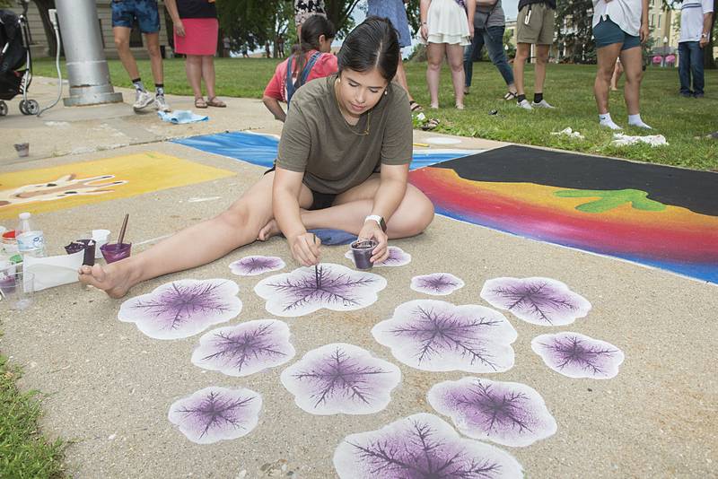 Kristin Throw, 19 of Dixon adds detail to her purple petunias Friday, July 1, 2022 during the Petunia Fest’s Brush and Bloom event at the old Lee County Courthouse.