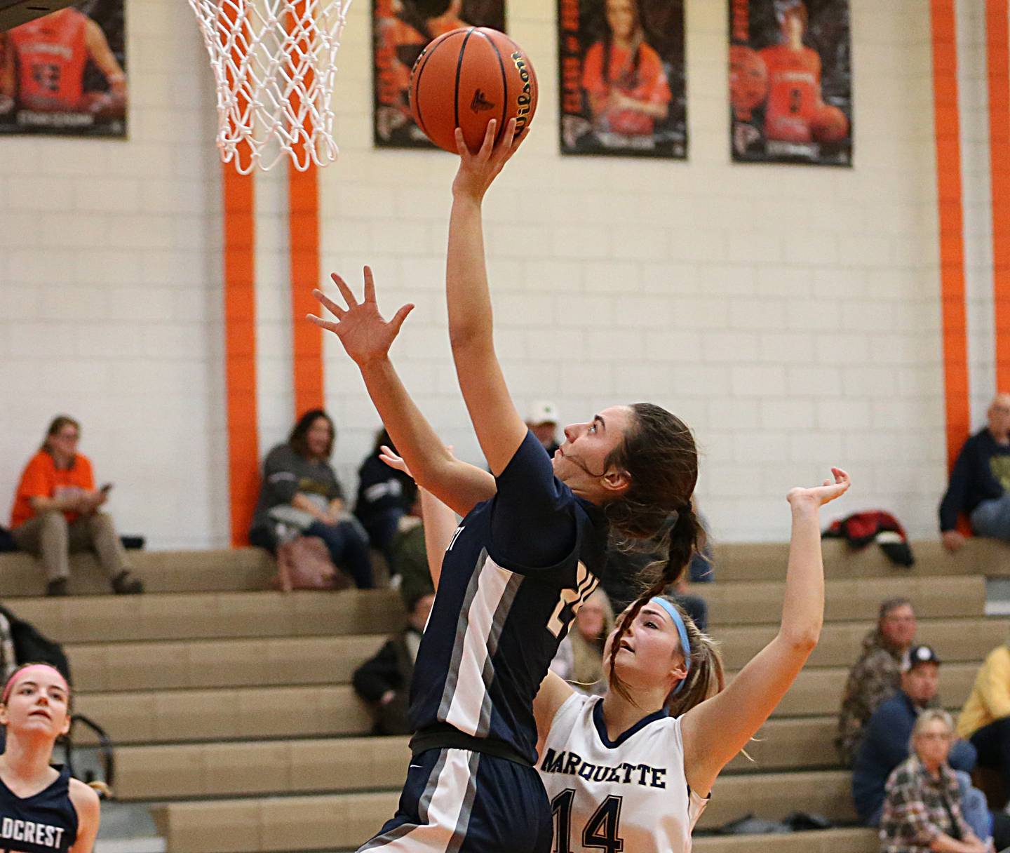 Fieldcrest's Ashlyn May (24) works her way around Marquette's Izzy Garkey (14) to score on a layup in the Integrated Seed Lady Falcon Basketball Classic on Thursday, Nov. 17, 2022 in Flanagan.