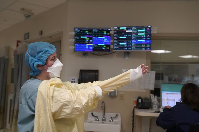 FILE - A nurse suits up with protective gear before entering a patient's room at the COVID-19 Intensive Care Unit at Dartmouth-Hitchcock Medical Center, in Lebanon, N.H., Jan. 3, 2022. The omicron variant has caused a surge of new cases of COVID-19 in the U.S. and many hospitals are not only swamped with cases but severely shorthanded because of so many employees out with COVID-19. (AP Photo/Steven Senne, File)