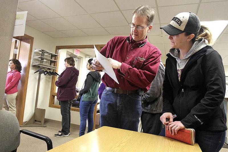 Early voters stand in line as Mark Rainey and daughter Amanda study a sample ballot before voting at the Algonquin Township offices in Crystal Lake on Monday, March 14, 2016. 1526 early votes were cast between February 29 and March 14.