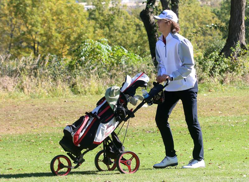 Henry-Senachwine's Carson Rowe pushes his cart down the fairway to hole number 2 during the Class 1A golf meet on Wednesday, Oct. 2, 2024 at Spring Creek Golf Course in Spring Valley.