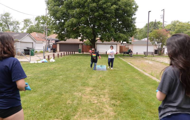 (left) Michelle Baladad of Oak Park and her daughters including Sam Widd, and (back left) Ceci and Annie Widd of Oak Park play bags during the family picnic held after the Berwyn Pride Parade Saturday June 15, 2024.