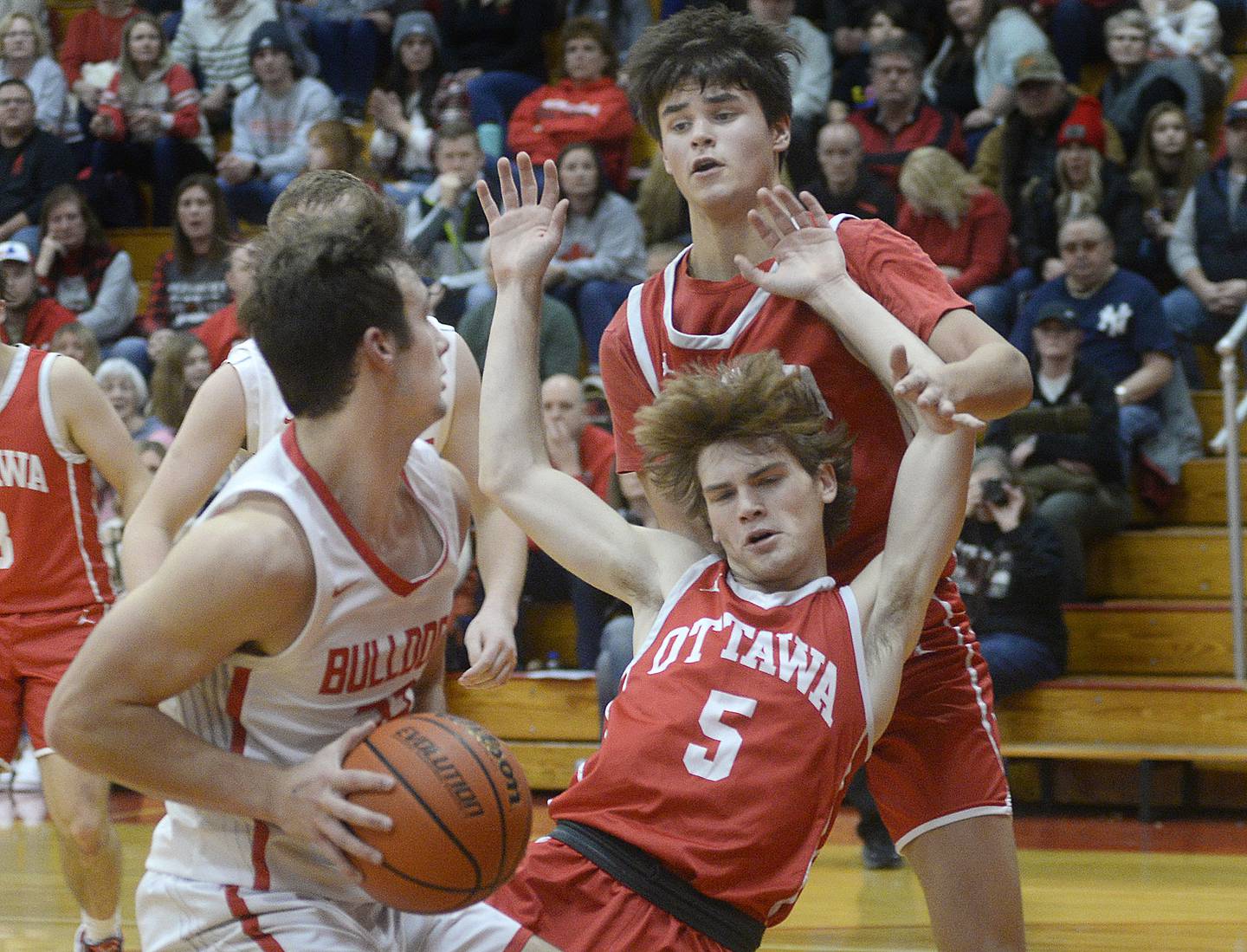 Ottawa's Aiden Mucci (5) falls back after contact with Streator's Christian Benning on Saturday, Dec. 10, 2022, at Pops Dale Gymnasium in Streator.