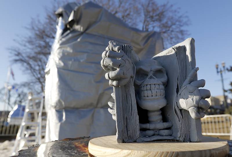 A model of the “Book of Souls” sculpture in front of a covered block of snow to protect it from rain and heat on Thursday., Jan. 30, 2025, Snow carvers have started carving their 15 massive snow sculptures for America’s Snow Sculpting Invitational during Winterfest in Lake Geneva. Winterfest, runs through Feb, 2, 2025. The warm and rainy weather has slowed down the carving of the snow.