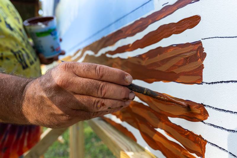 Doug Haffner of the Walldogs paints log on Streator mural on Thursday, Sept. 11, 2025 at City Park in Streator.