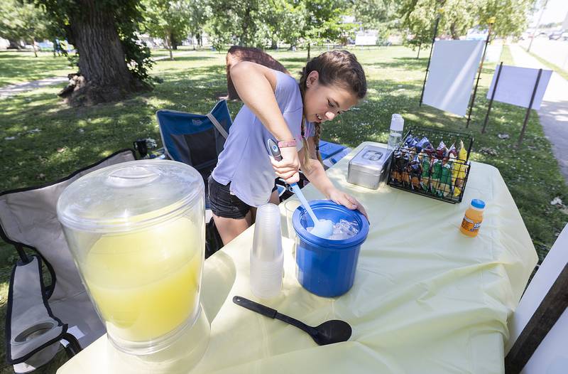 Vida Rubio, 11, scoops up ice for a customer Monday, June 23, 2025, at her lemonade stand in Dixon.