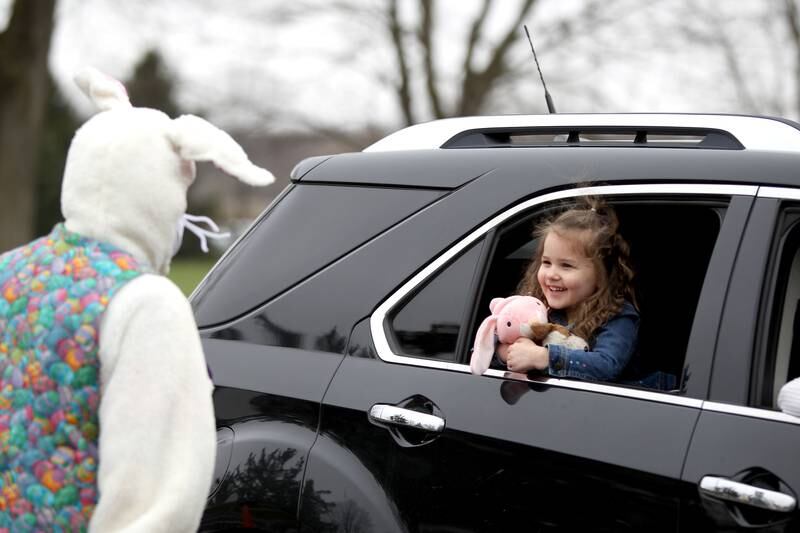 Parker Dixon, 3, of Elburn waves to Cheryi Lee, as the Easter Bunny during a drive-thru egg hunt hosted by the Elburn Lions Club on April 4. The event adhered to the state-mandated social distancing guidelines due to the coronavirus pandemic.