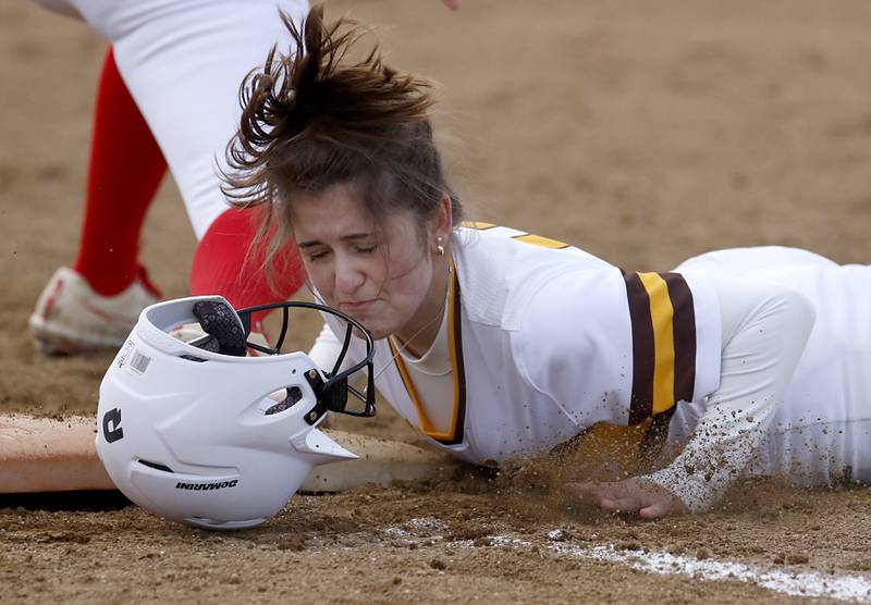 Jacobs’ Clare Piazza looses her helmet as she tries to get back to first base after a fly ball was caught during a nonconference softball game against Palatine Monday, March 20, 2023, at Palatine High School.
