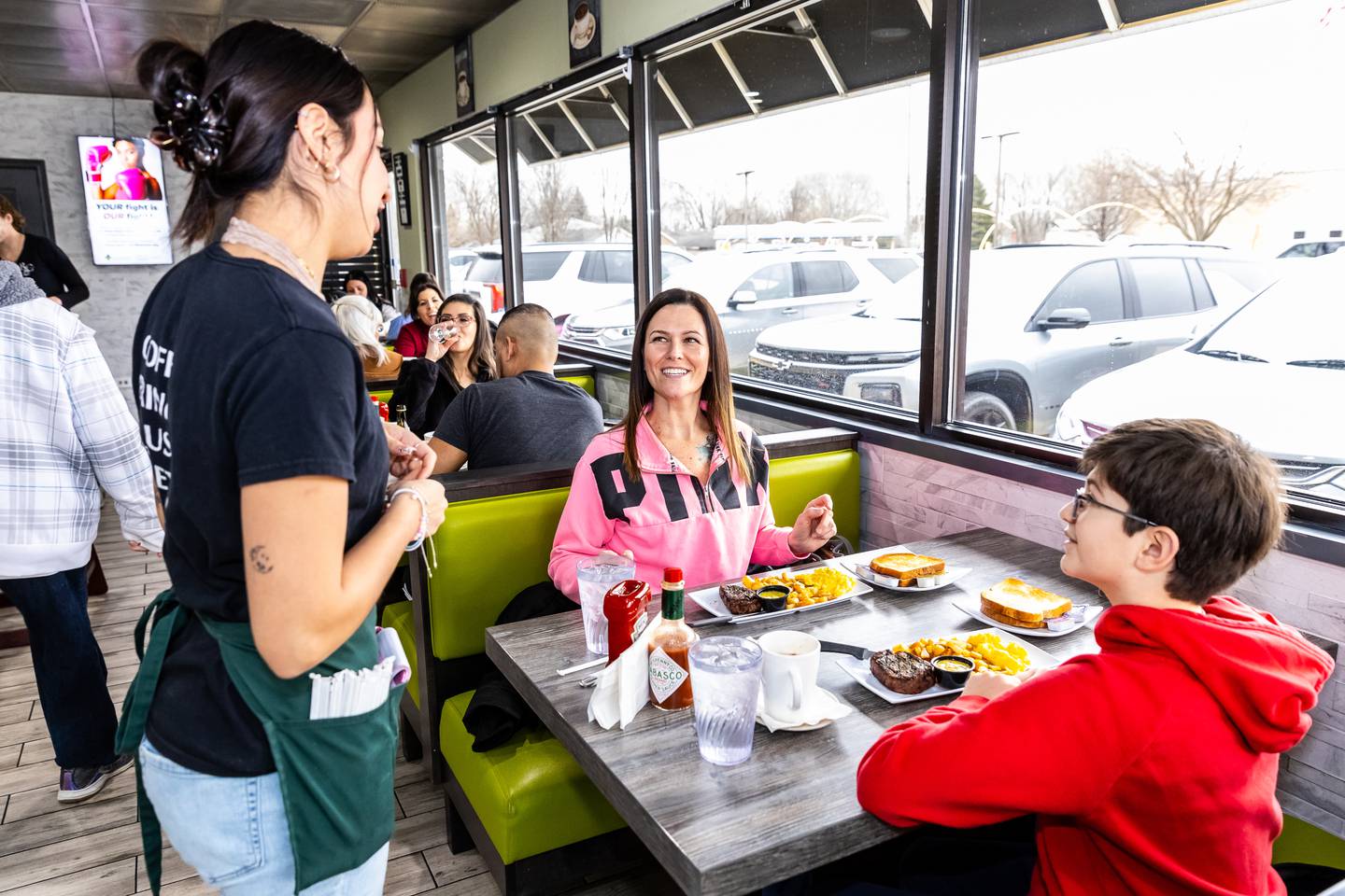 Server Daisy Cortez delivers two plates of Steak and Eggs to Joliet residents MaryBeth and Julian Lynch at Rosemary Cafe on Feb. 2, 2025.