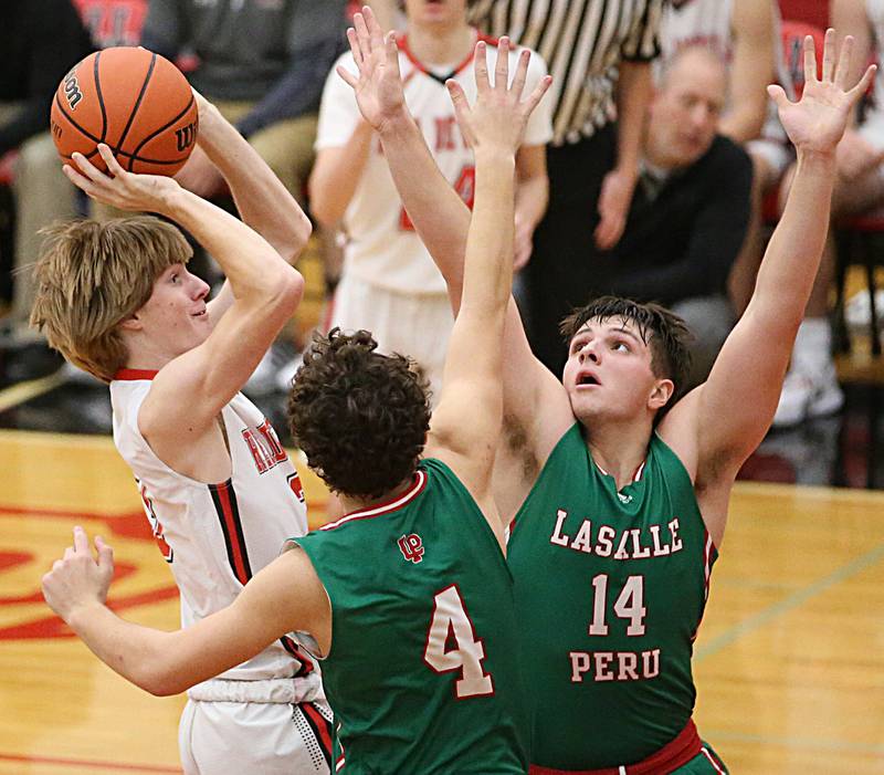 Hall's Max Bryant (3) pulls up in the lane to shoot a shot over L-P's Jack Jereb (4) and teammate Nolan Van Duzer (14) on Tuesday, Nov. 29, 2022 at Hall High School in Spring Valley.