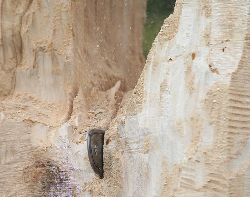 Bud Hainzinger of Morris udes his chainsaw to carve a cross in a tree stump at St. Johns Lutheran Church on Friday, Nov. 3, 2023 in Peru.