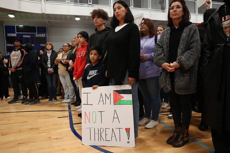 A little boy holds a sign with his family at a vigil for Wadea Al-Fayoume at Prairie Activity & Recreation Center on Tuesday, Oct. 17, 2023 in Plainfield.