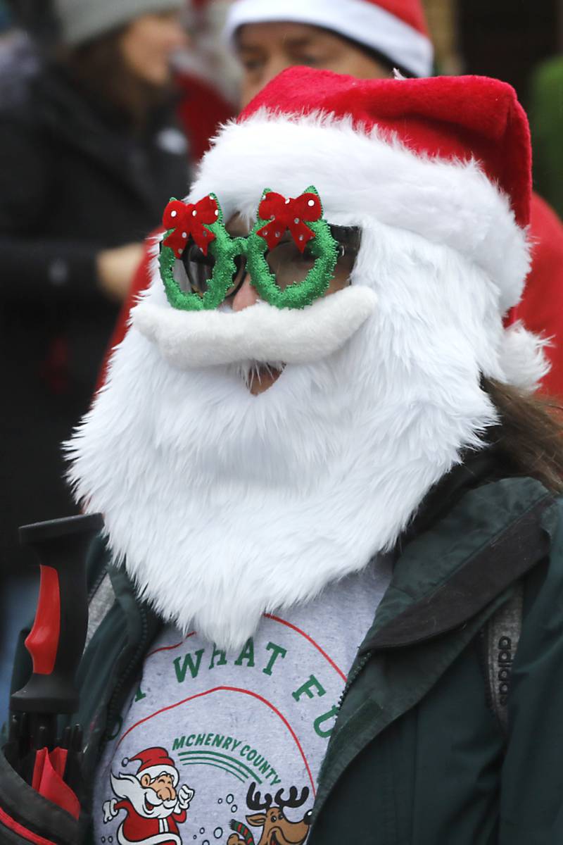 Erin Reinhart sports a full beard and sunglasses at the start of 5K race during the McHenry County Santa Run For Kids Sunday morning, Dec. 3, 2023, in Downtown Crystal Lake. The annual event raises money for agencies in our county who work with children in need.