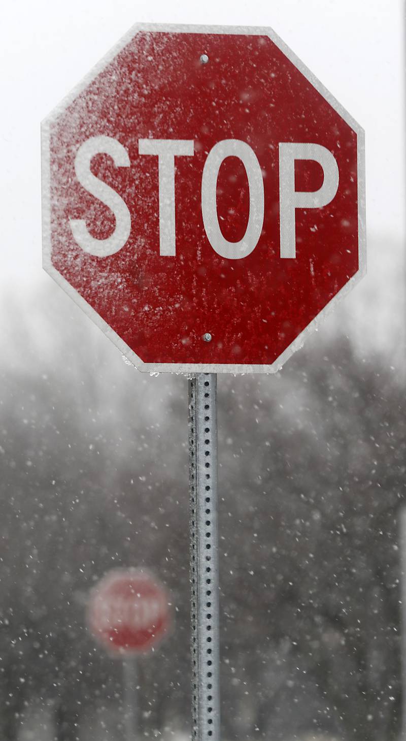 Snow sticks to two stops signs Thursday, March 31, 2022, in the parking lot of the  McHenry County Michael J. Sullivan Judicial Center in Woodstock. Areas of McHenry County faced a day of rain and snow showers.