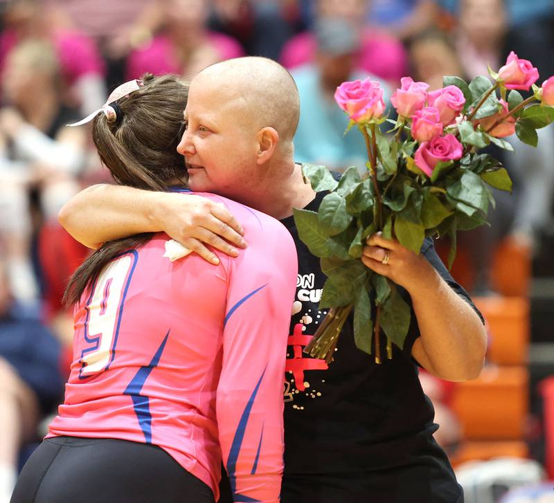 Becky Cleveland receives pink roses from volleyball players as she is recognized as the guest of honor before the Genoa- Kingston volleyball team's Volley for the Cure breast cancer fundraiser match against Oregon Wednesday, Sept. 21, 2022, at Genoa-Kingston High School. Cleveland, a former student and teacher at Genoa-Kingston High School is currently battling cancer.