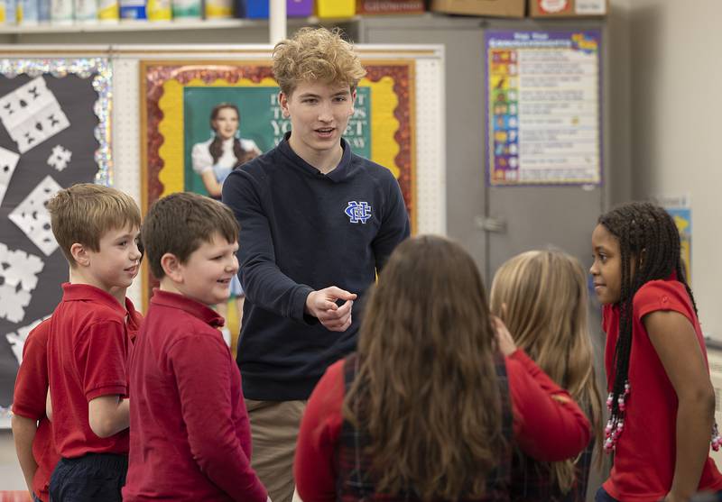 Newman freshman Brandon Pfeiffer gathers his team of third graders Wednesday, Jan. 29, 2025, for a game of charades at St. Mary’s School in Dixon. NHS students visited the school to play games with the kids in celebration of Catholic Schools Week.