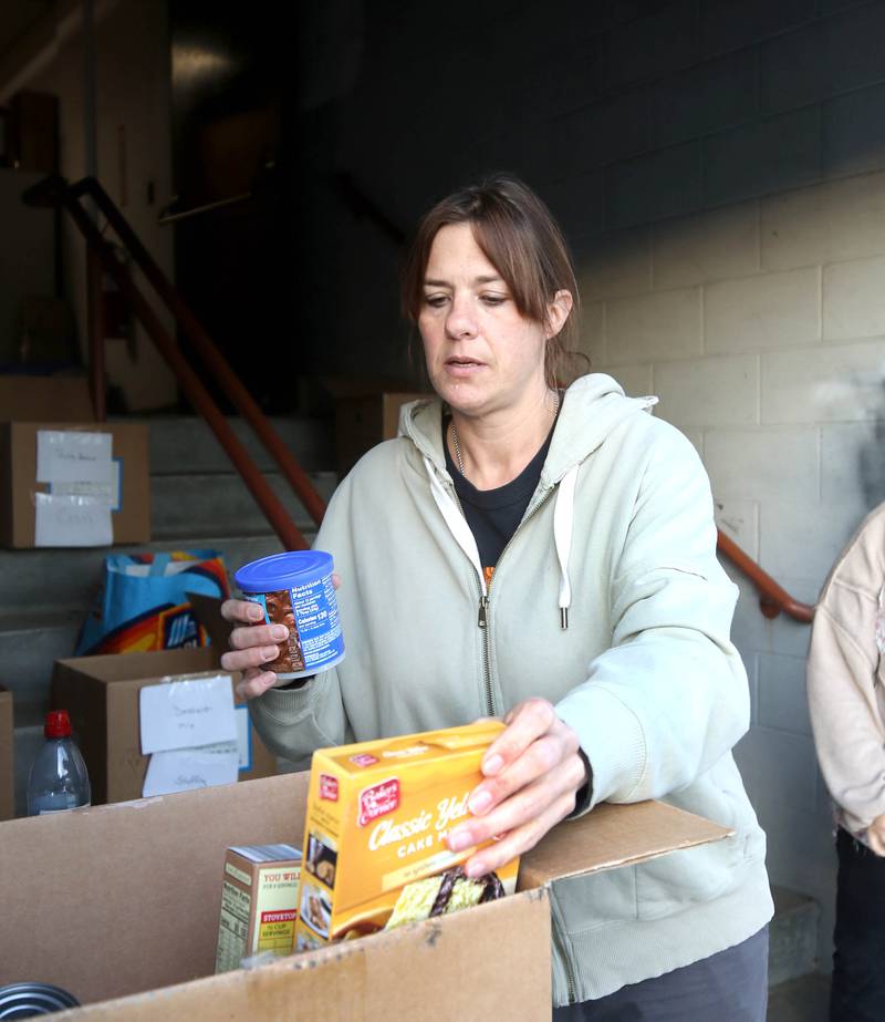 Angela Schiola, Stage Coach Players community outreach chair, sorts donated food into boxes Tuesday, Nov. 12, 2024, at the Stage Coach Theatre in Dekalb. The food collected will be assembled into dinner boxes to provide local families with a Thanksgiving meal.