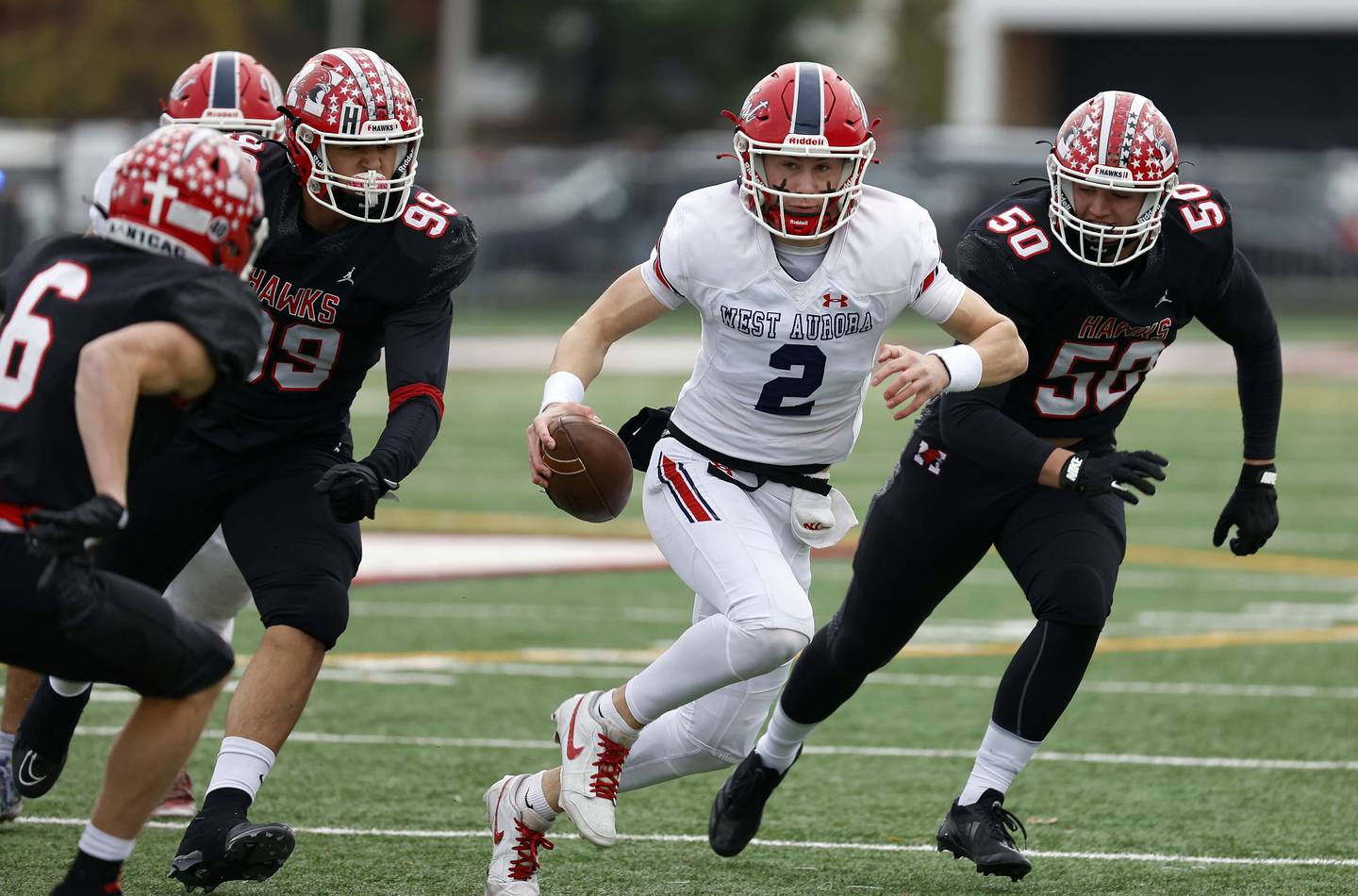 West Aurora's Mason Atkins (2) looks to move upfield past Maine South's Tyler Fortis (99) and Dean Arvanitis (50) during the IHSA Class 8A second round playoff game Saturday, Nov. 9, 2024 in Park Ridge.