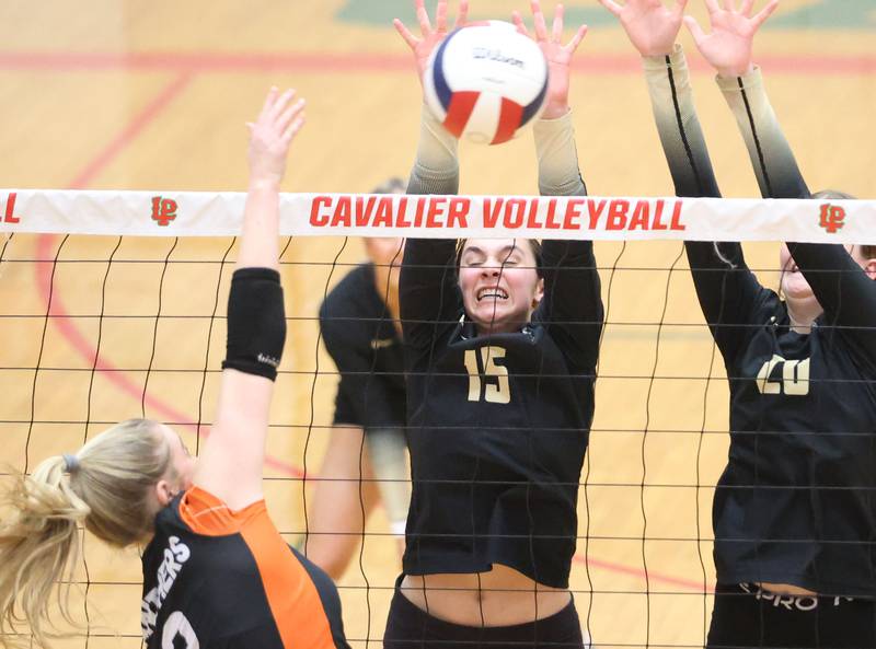 Sycamore's Lillian Jones blocks the ball with teammate Ava Wente-Argo against Washington's Jenna Aeschliman during the Class 3A Sectional semifinal game on Tuesday, Nov. 4, 2025 in Sellett Gymnasium at L-P High School.