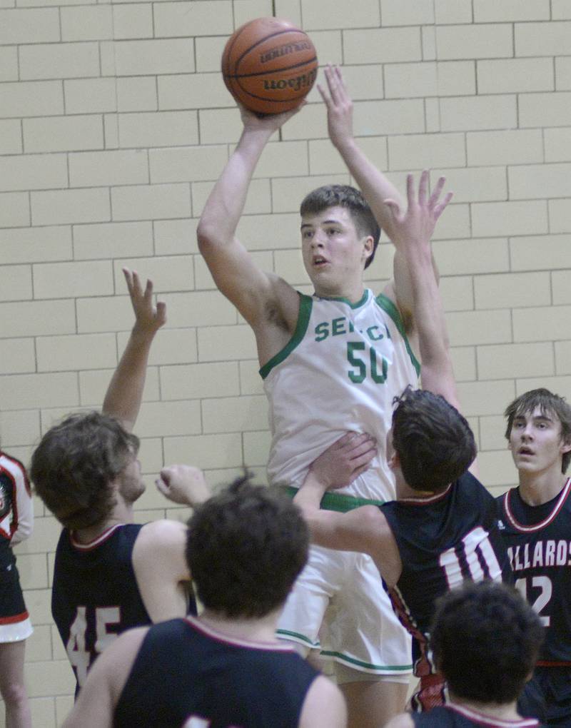 Seneca’s Lane Provance gets a shot off over the block attempts by the mallard defense in the 1st period Friday against Henry-Senachwine at the old west campus gym of Seneca.