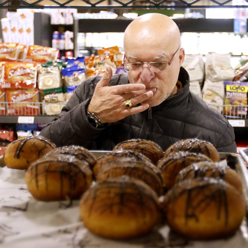 Nick Finia of McHenry licks his fingers after selecting a paczki Wednesday, Feb. 15, 2023, as he shops at Deli 4 You, 1501 S. Randall Road in Algonquin. Area bakeries are prepping for the lead-up to Lent when paczki are traditionally eaten. Deli 4 You will make and sell around 30,000 paczki this week.