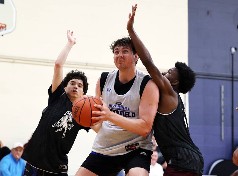 Riverside Brookfield's Stefan Cicic goes to the basket as he is double-teamed by Morton during the Riverside Brookfield Shootout for boys varsity basketball in Riverside on Friday, June 16, 2023.