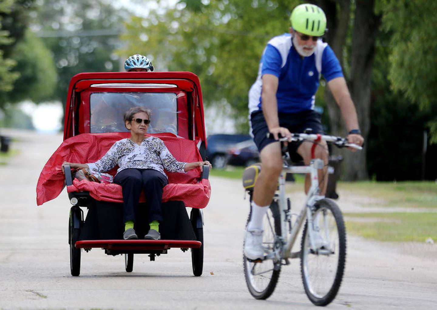 Dolores Roti of Hebron goes on a ride through town on a Trishaw operated by Cycling Without Age member Peg Bolm of McHenry, with Jim Bolm leading the route on Tuesday, Aug. 18, 2020 in Hebron.  The organization plans on offering more rides to seniors in McHenry County to give them a sense of joy and experience the outdoors in a new way.
