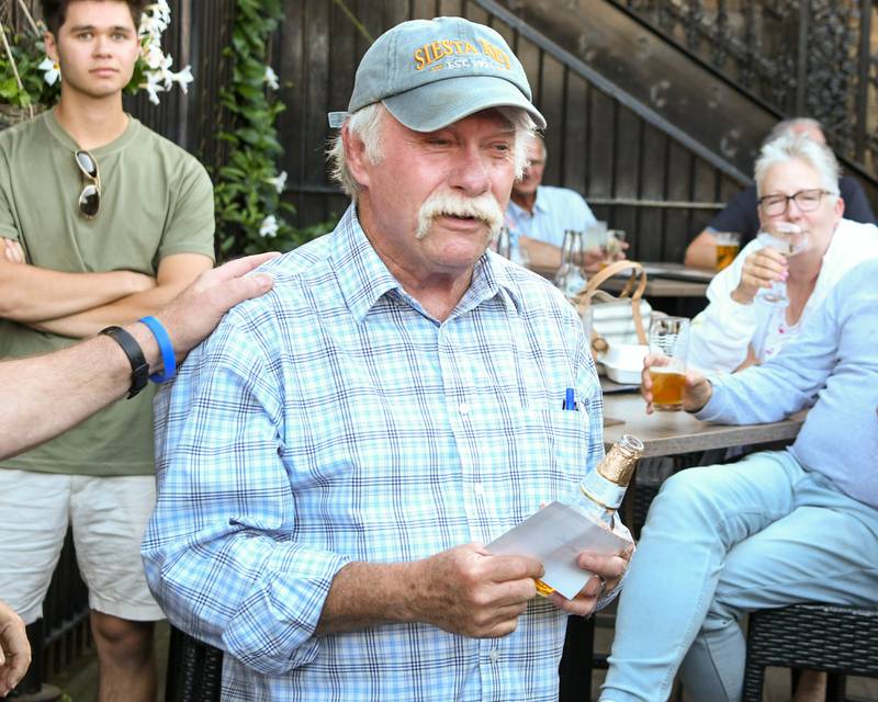 Lee Jacobson of Elburn, who served in the Navy, gets congratulated after holding the winning ticket of the Geneva American Legion 50/50 raffle on Thursday Aug. 21, 2025.