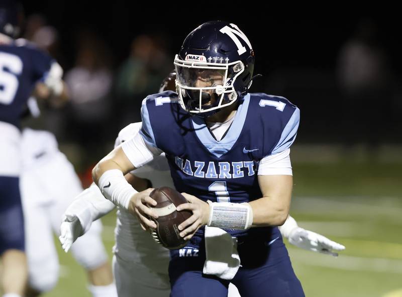 Nazareth's (1) Logan Malachuk scrambles during the varsity football game between Joliet Catholic and Nazareth academies in La Grange Park.