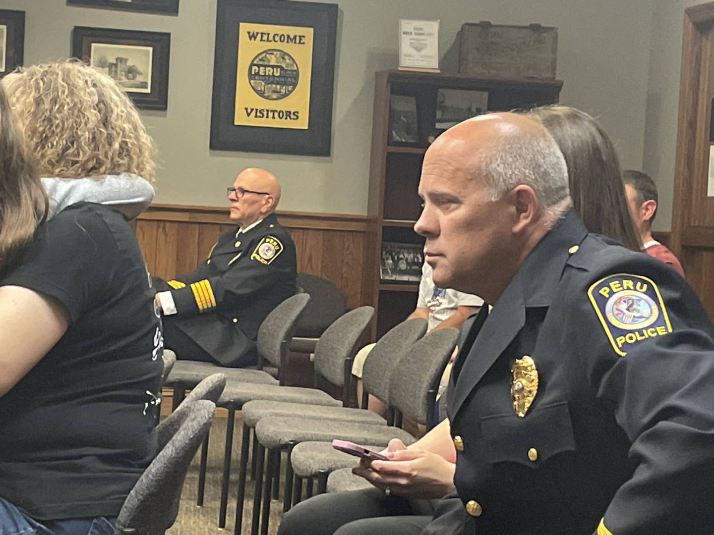 Bill Sommer (right) listens as Peru Police Chief Sarah Raymond discusses his promotion to sergeant Monday, May 18, 2026, at the Peru City Council meeting.