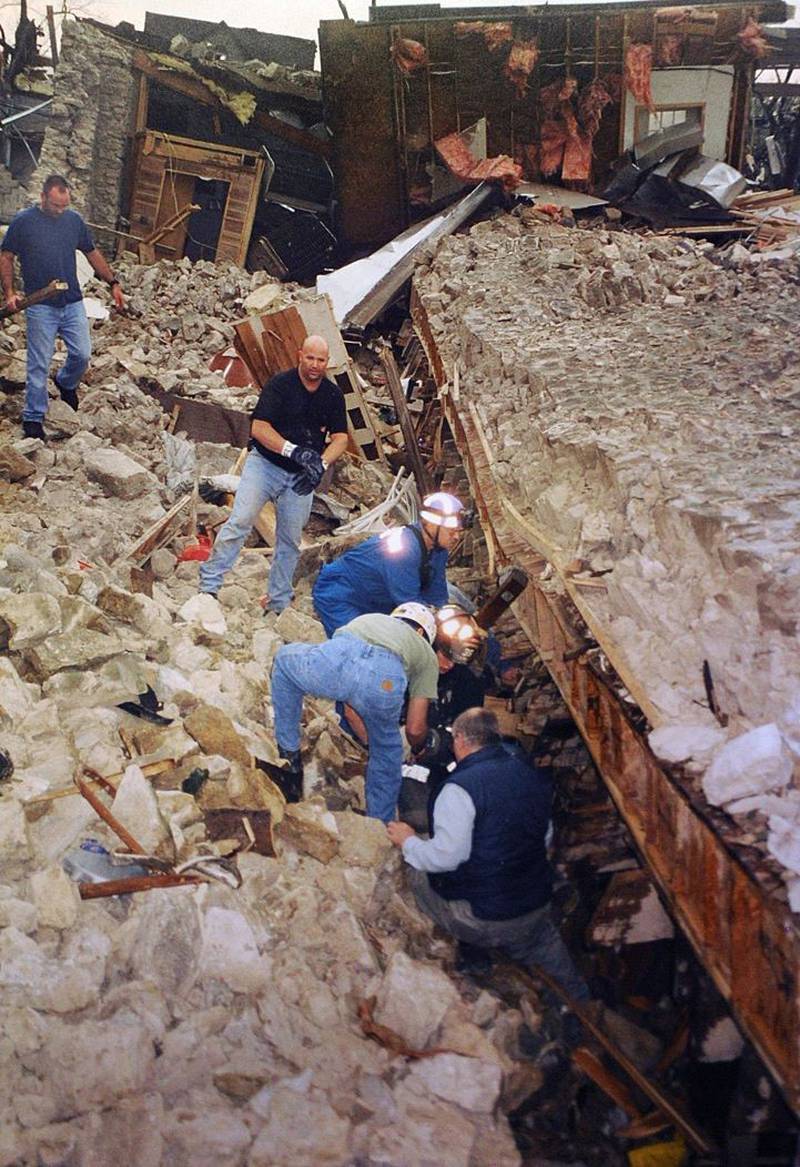 Workers remove stone and other materials to try to free victims pinned underneath the Milestone Tap on Tuesday, April 20, 2004 in Utica.
