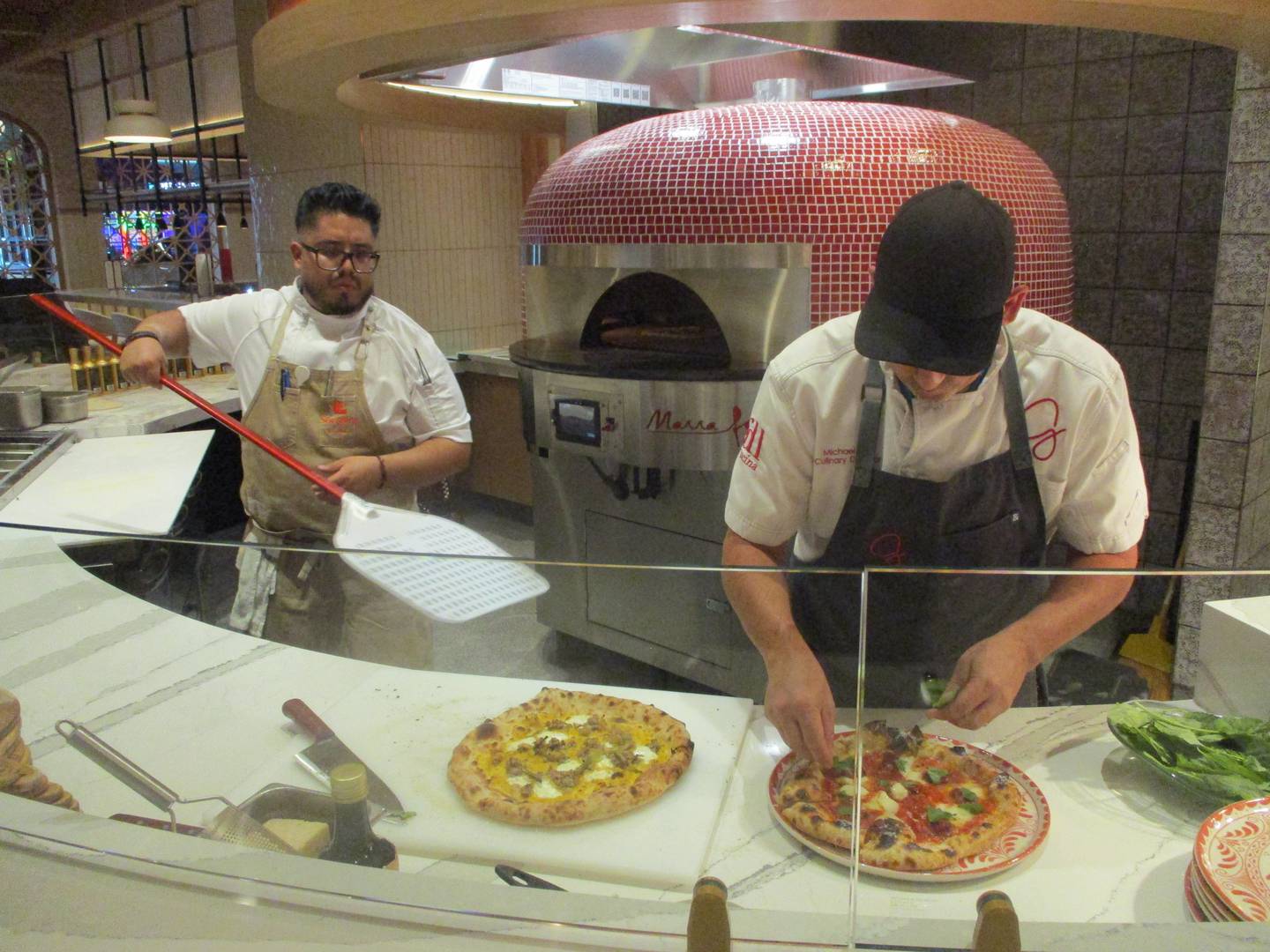 Michael Gill, culinary director for Giada De Laurentiis restaurants, and Executive Chef Elfego Morales-Perez prepare pizzas at the Sorellina by Giada restaurant in Joliet on Thursday. Aug. 5, 2025