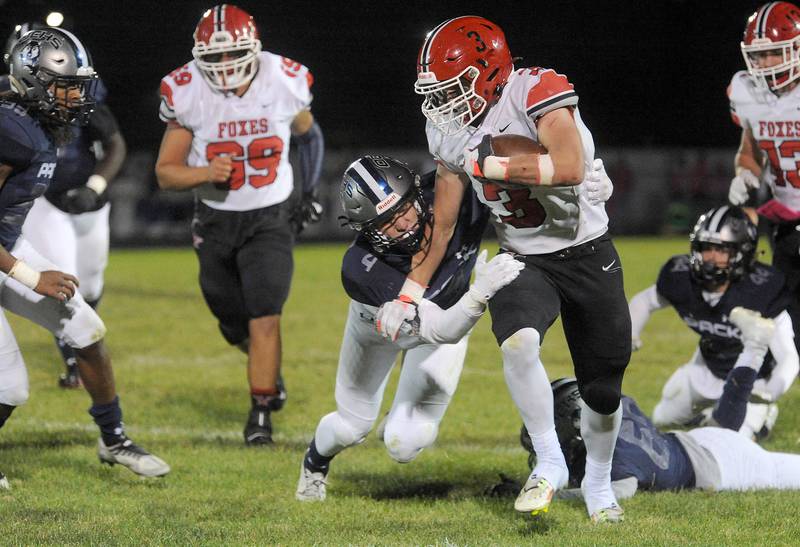 Oswego East defender Maxwell Schwertley gets his hands on Yorkville running back Josh Gettemy (3) during a varsity football game at Oswego East High School on Friday, Oct. 7, 2022.