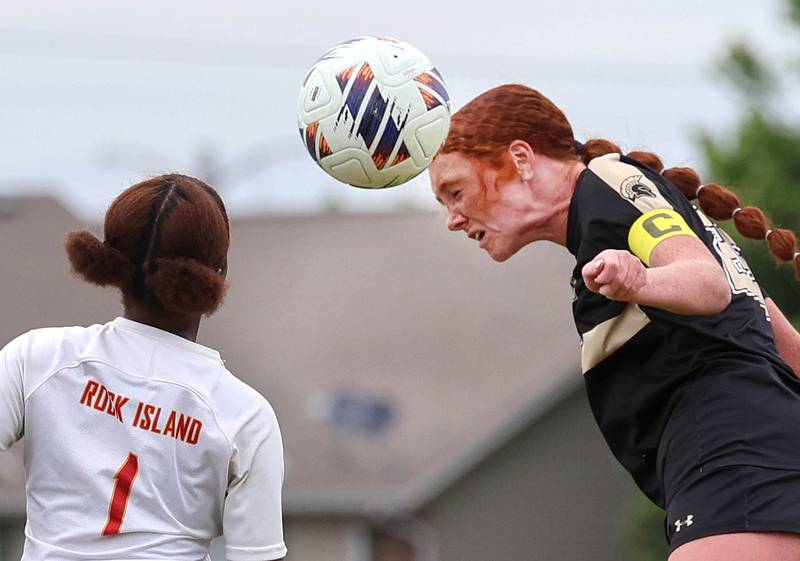 Sycamore's Isabelle Segreti heads the ball by Rock Island's Martha Abuke Friday, May 22, 2026, during their Class 2A regional championship matchup at Sycamore High School.