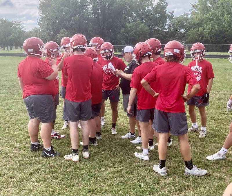 Hall assistant coach Mike Filippini runs over plays during the Red Devils first day of practice Monday morning.