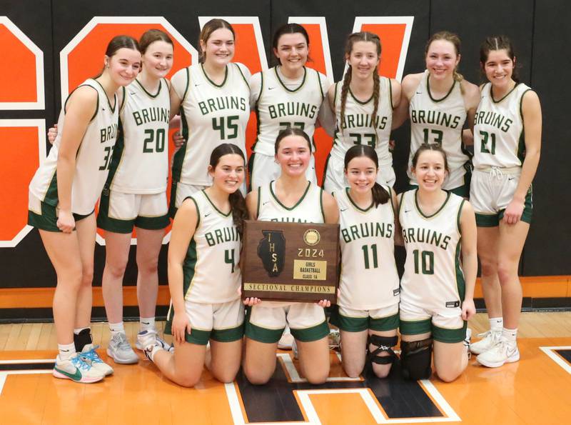 Members of the St. Bede Lady Bruins pose with the Class 1A Sectional plaque after defeating Serena on Thursday, Feb. 22, 2024 at Gardner-South Wilmington High School.