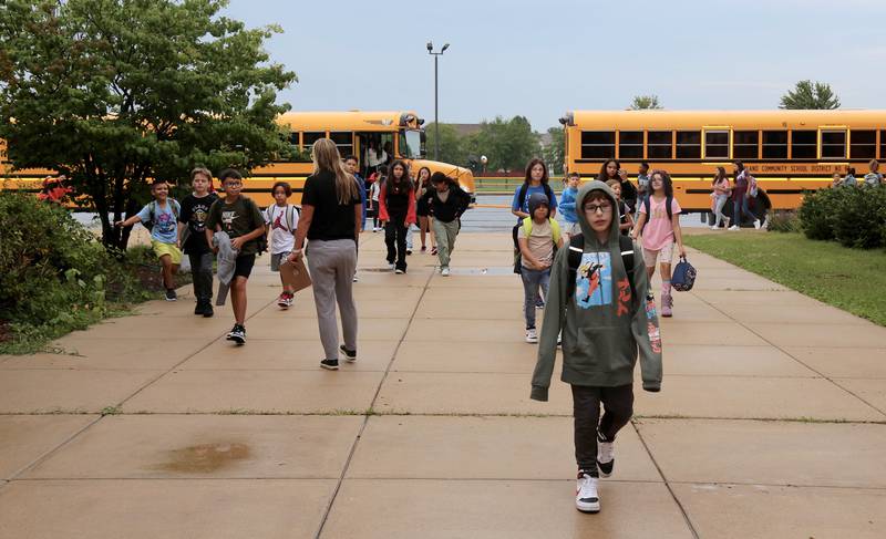 Students get off the bus on the first day of school at Emily G. Johns School in Plano on Thursday, Aug. 17, 2023.