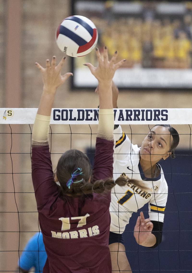 Sterling’s Nia Harris hammers a shot against the Morris’ Olivia Peterson Thursday, Oct. 30, 2025, in the Class 3A volleyball regional.