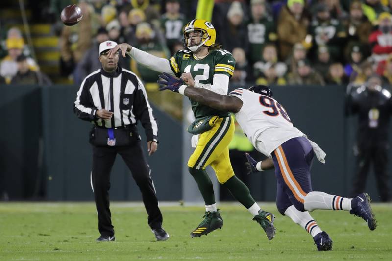 Green Bay Packers' Aaron Rodgers thorws as he is hit by Chicago Bears' Bilal Nichols during the first half Sunday