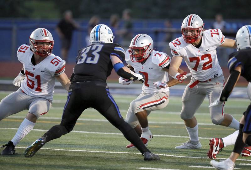 Palatine's Dominik Ball (7) turns upfield with some support from his teammates Stark Frank (51) and Downer Evan (72)  as they take on St. Charles North's Jake Furtney (33) Friday August 25, 2023 in St. Charles.