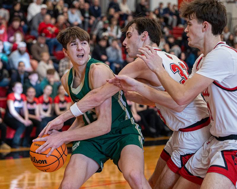 St. Bede's Graham Ross (13) holds ball at hip as Braden Curran (33) of Hall reaches across body on Saturday, January 31, 2026 at Hall High School in Spring Valley.