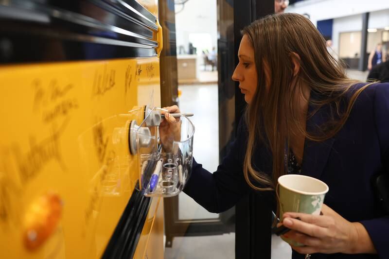State Senator Rachel Ventura, D-43, signs a bus at the grand opening of the Lion Electric manufacturing facility Friday, July 21st, 2023 in Joliet.