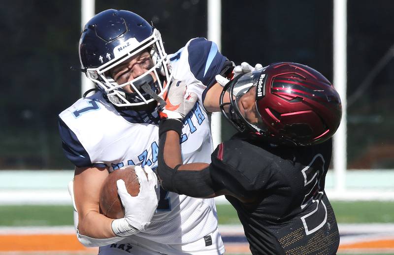 Nazareth's Zach Hayes stiff arms Peoria's Phil Ellis during their IHSA Class 5A state championship game Saturday, Nov. 26, 2022, in Memorial Stadium at the University of Illinois in Champaign.
