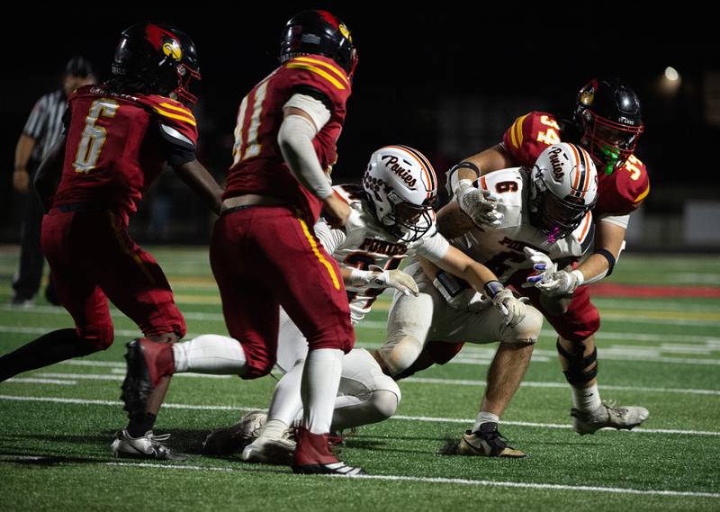St. Anne's Brandon Schoth, right, brings down South Fork's George Bailey as he carries the ball in a game on Friday, September 26, 2025.