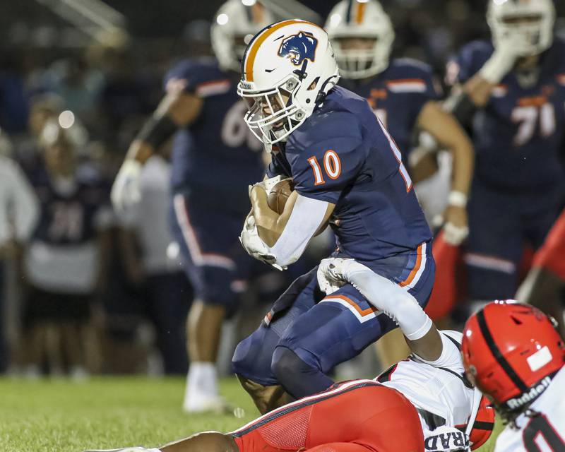Oswego's Mariano Velasco (10) is brought down after catching a short pass during football game between Bolingbrook at Oswego Friday, Sept 12, 2025  in Oswego.