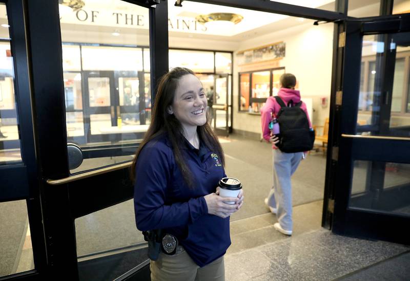 St. Charles Police Officer Jennifer Larsen, the school resource officer at St. Charles East High School, greets students as they arrive at the school one recent morning.