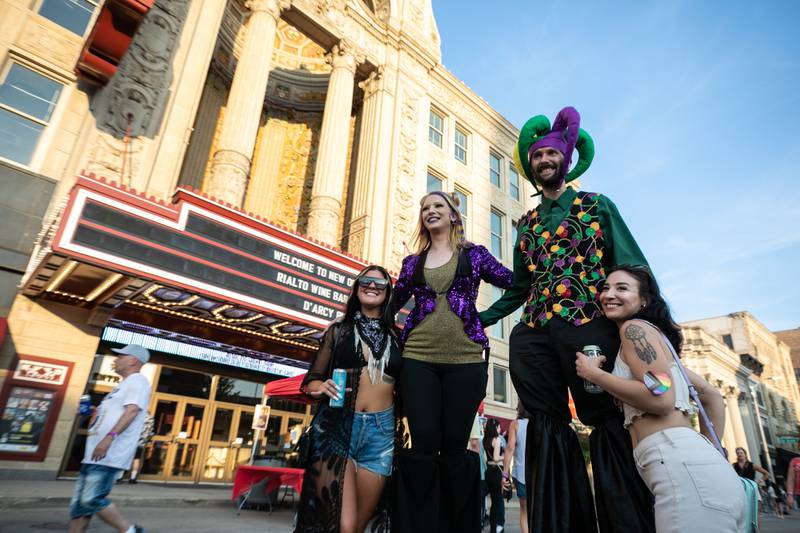 Amber Daraska, left, and Alysianna Almazan get a photo with stilt walkers Jamie Lee, center left, and Kegan Depatis of Intrinsic Arts at the New Orleans North Festival, on Friday, June 2, 2023.