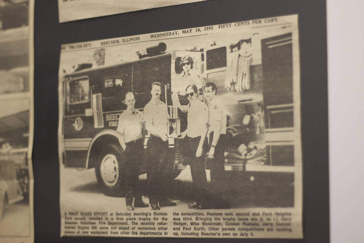 Retired Beecher Deputy Fire Chief Jerry Conner (fourth from the left) is one of the firefighters featured in a 1995 photo that seen on Aug. 18, 2025, hanging on the wall of Beecher Fire Protection District, 711 Penfield St. Conner and other firefighters had responded to the 1990 tornado in Plainfield.