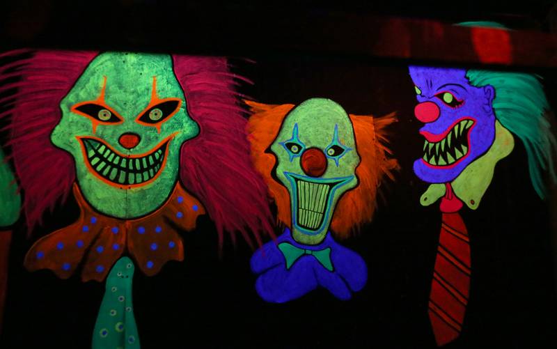 Clowns illuminate under a blacklight during the Nightmare Haunted Attraction on Saturday, Oct. 14, 2023 at the Bureau County Fairgrounds in Princeton.